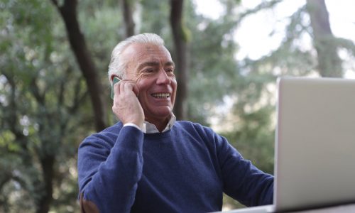 man with grey hair using a smartphone